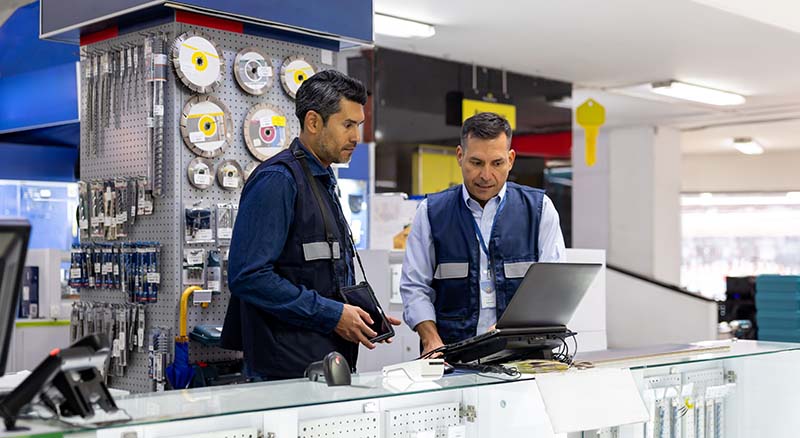 Two people in hardware store looking at a computer