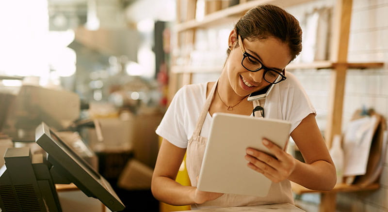 Person using a tablet and on the phone while working