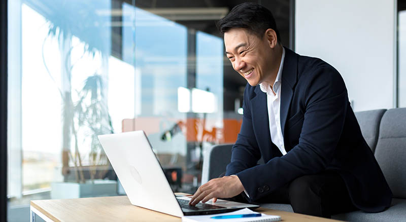 Person looking at laptop and smiling
