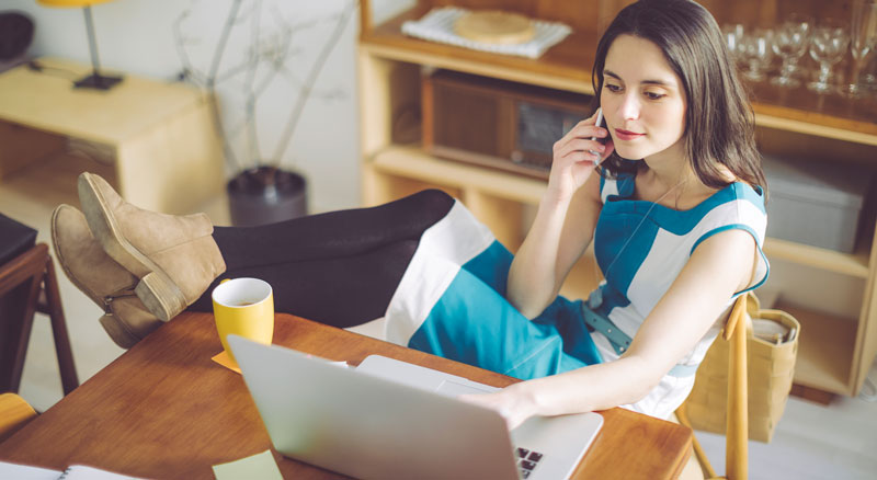 Woman uses laptop to view her business accounts from one convenient dashboard within Banner Online Banking