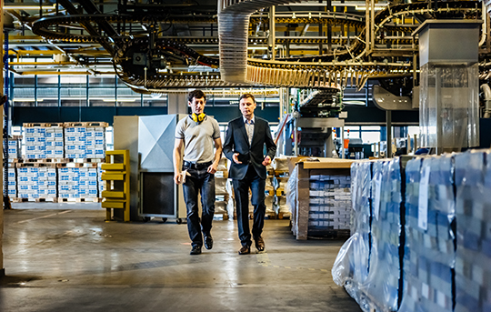 Two men walking and discussing in warehouse