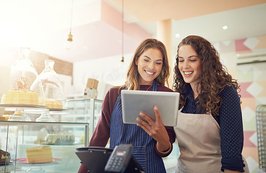 Small business employees looking at tablet in store
