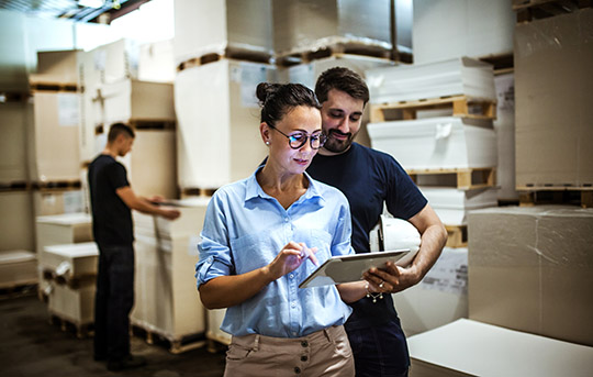 Business owners on tablet in warehouse