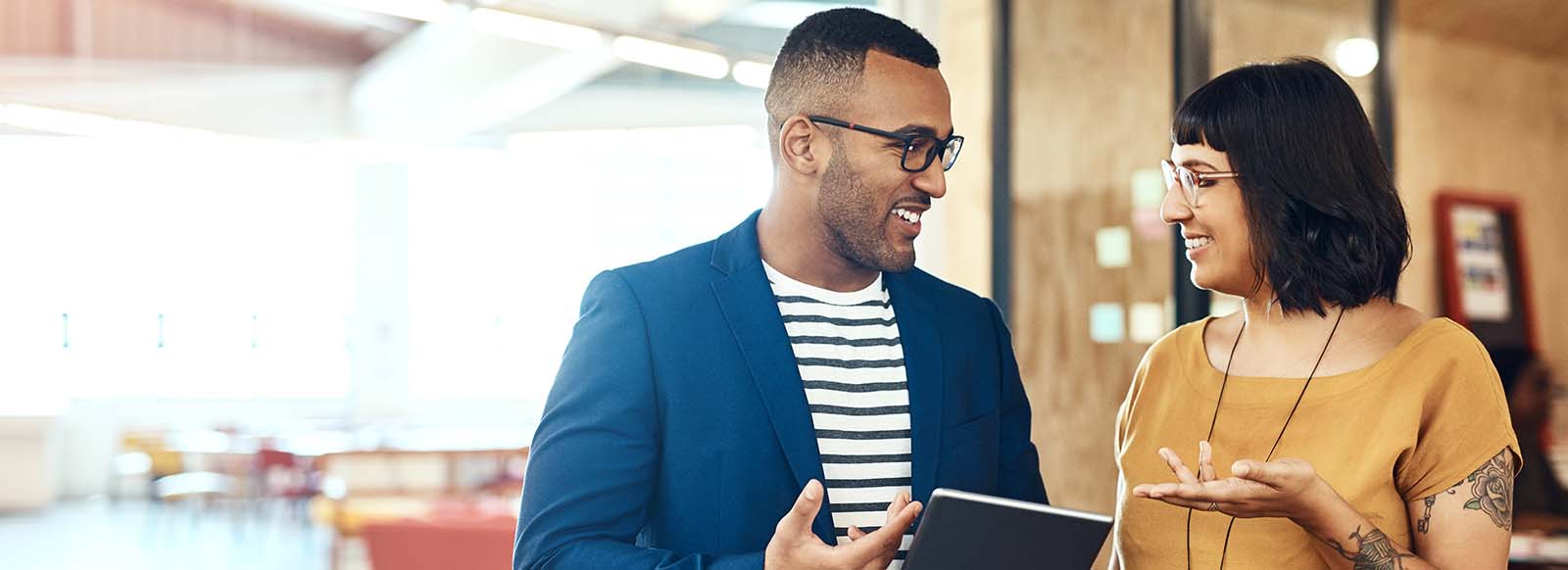 Co-workers in discussion with tablet in hand