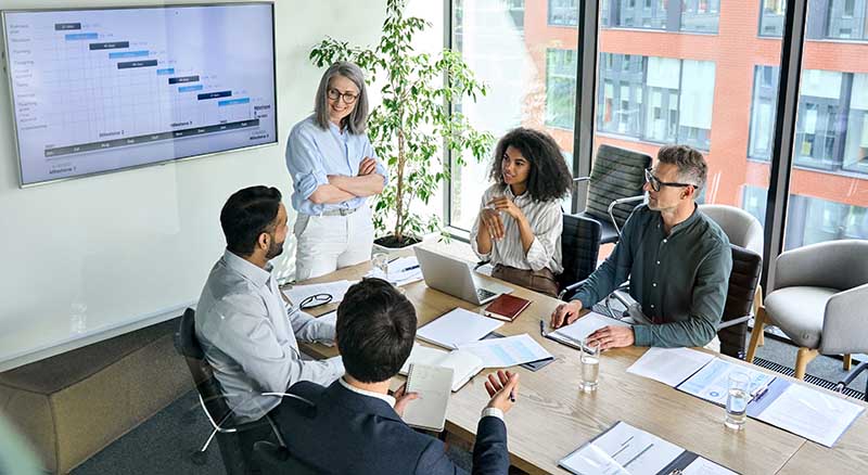 Colleagues discussing presentation in a business meeting