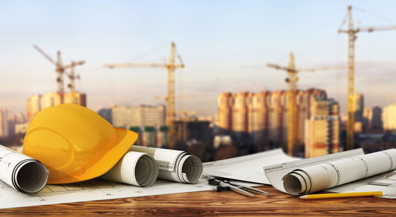 Hard hat and design plans on an income property construction site financed by Banner Bank