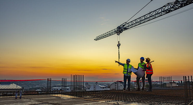 Three construction workers on top of a building