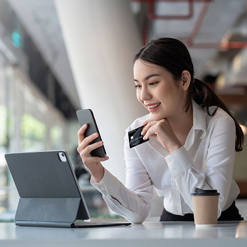 Person looking at phone with card in hand