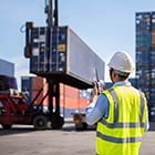Person with walkie talkie while cargo containers are moved