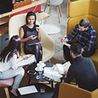 three people talking around a coffee table