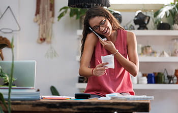 Small business owner looking at receipts while on phone