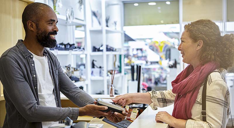 Person paying with card reader in a shop