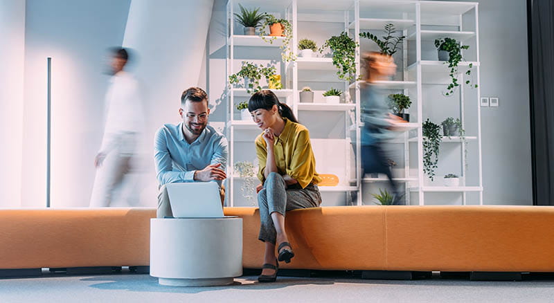 Two people looking at a laptop in an office