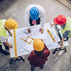 Contractors standing around a business plan with owners