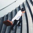 Man with briefcase walking up stairs