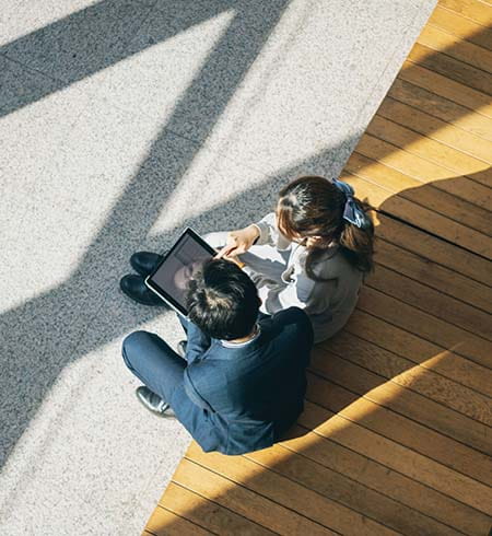 Two people looking at a laptop from above