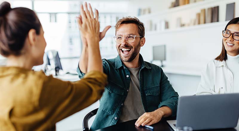 Colleagues high fiving in an office