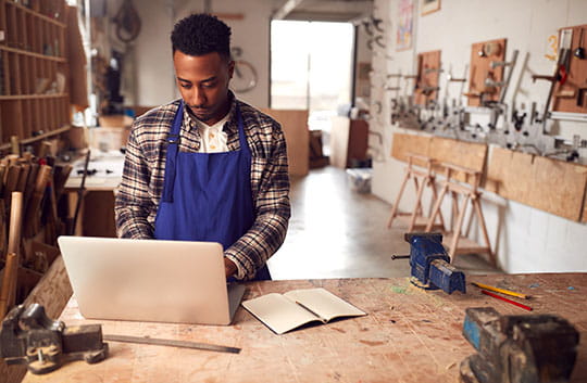 Small business owner on computer in shop