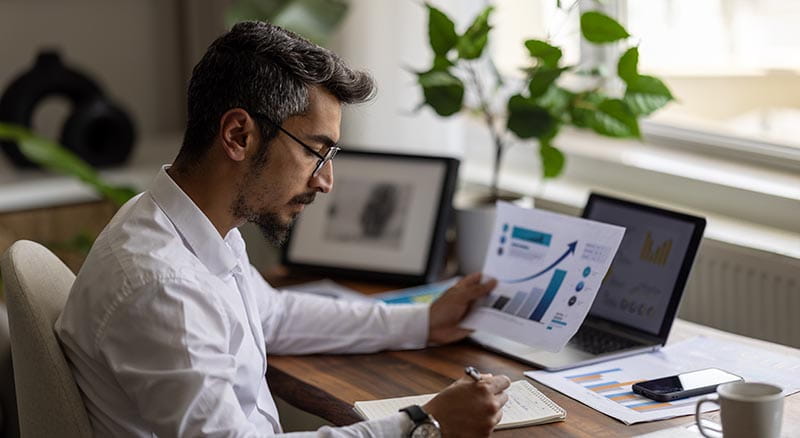 Person looking at chart and writing at desk