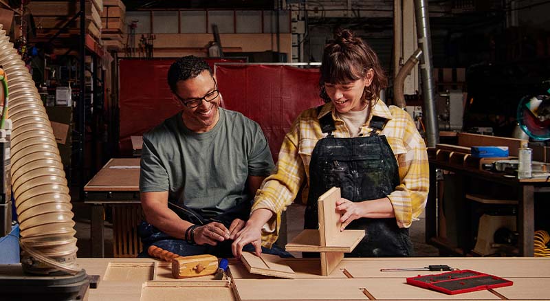 Two people working in a wood shop