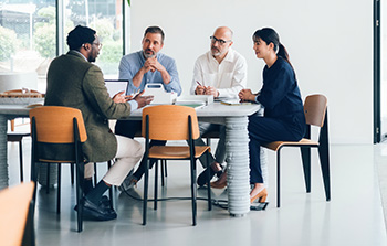 Four people meeting around an office table