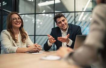 People smiling and in discussion at an office table