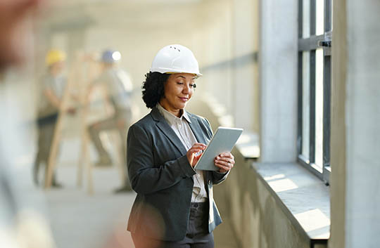 Person in hard hat looking at tablet