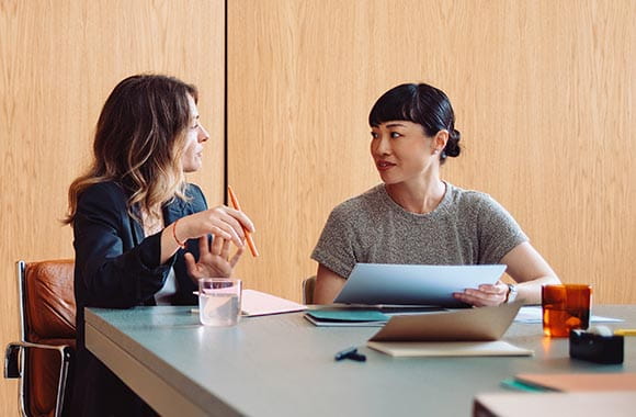 two people talking and looking at a tablet