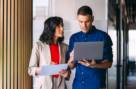 Person on laptop talking to a colleague
