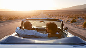 Couple driving car in desert