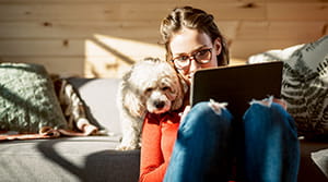20 or 30 something person looking at tablet next to dog
