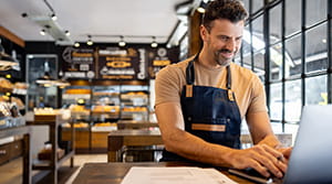Person in bakery on a laptop