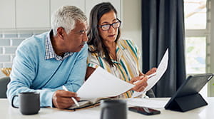 Two people in discussion at counter looking at papers