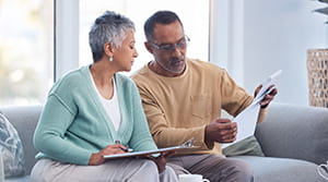 Two people on couch looking at paperwork