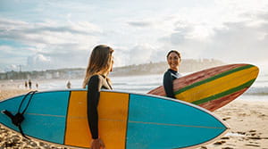Two people on the beach with surfboards