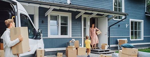 Person moving boxes from a van to a home