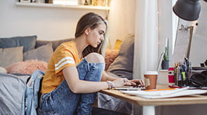 College student on laptop in dorm room