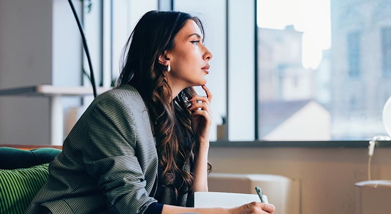 person thinking and looking out a window