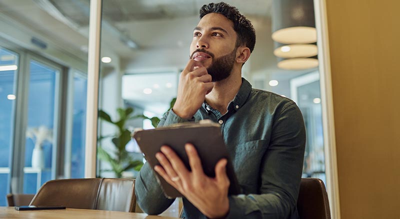 Person holding tablet and thinking