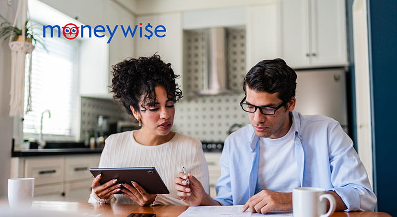 Two people looking at a tablet and papers in the kitchen