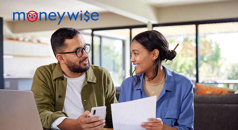 Couple looking at paperwork in discussion with MoneyWise logo