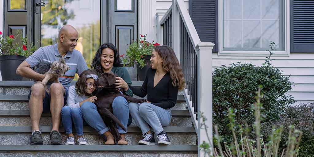 Family sitting on porch steps with pets