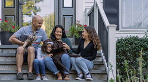 Family sitting on porch steps with pets