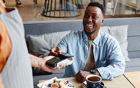 Person using phone to pay at a cafe