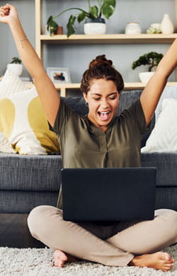 Excited woman looks at laptop