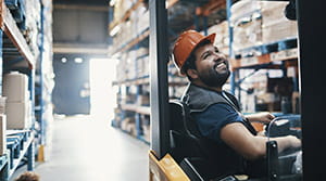 Worker operating forklift in warehouse