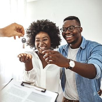 Couple receiving keys from real estate agent