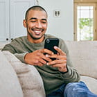 Person looking at phone sitting on the couch
