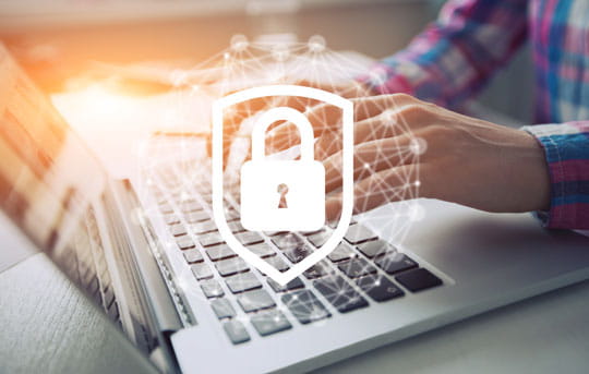 Security icon overlays person typing on laptop
