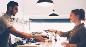 Woman using phone to pay at cafe